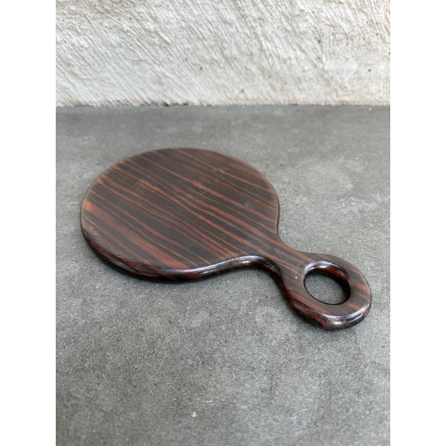 Nice round hand mirror made of Macassar ebony with a beveled mirror insert. The handle is mark “Turtle ____”.