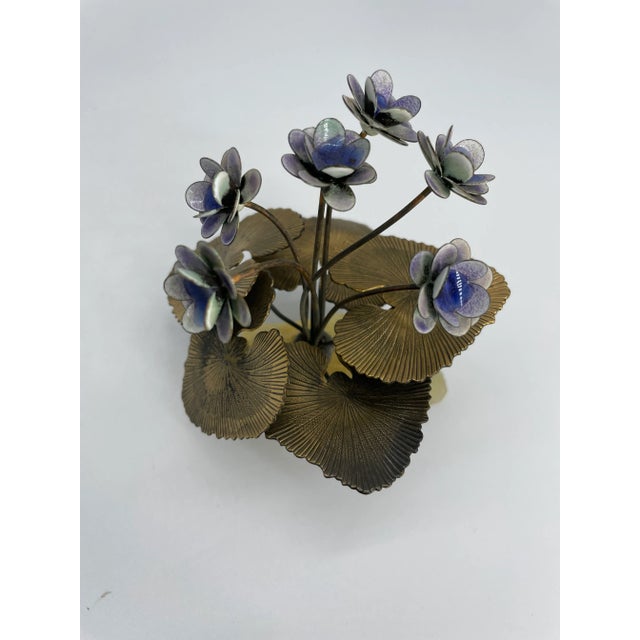 This whimsical sculpture depicts six purple flowers surrounded by large lily-pad like leaves with great veined detail. All...