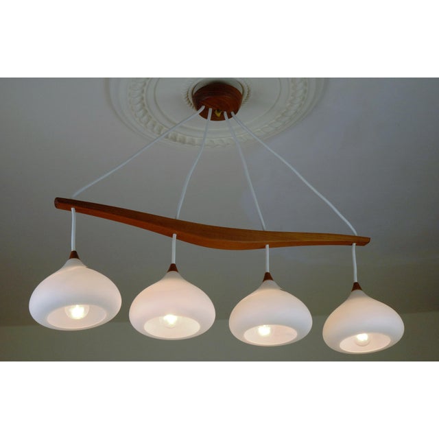 A Swedish hanging lamp produced during the 1960s, combining warm natural materials with softly sculptural glass forms...