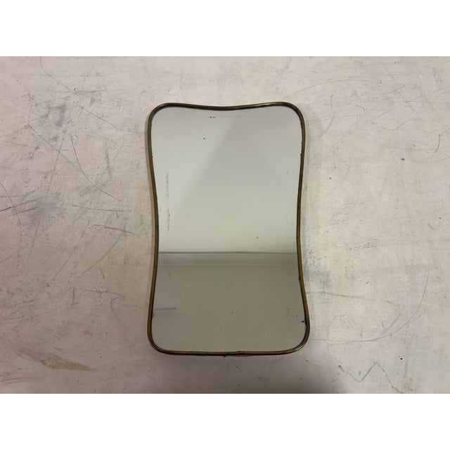 This elegant 1950s Italian wall mirror is defined by its slender, organically contoured brass frame. The gently undulating...