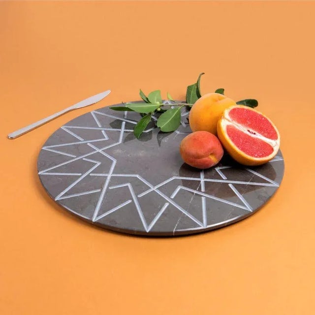 Graphite marble palatina in round format with satin engraving is a plate - centerpiece that contains, synthetically in its...