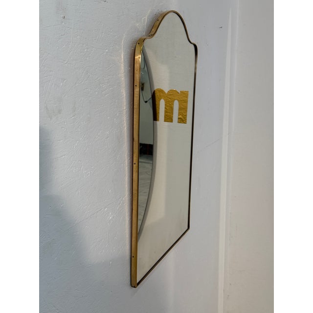 An Italian mid-century wall mirror featuring a rectangular shape with a softly arched top. Framed in slim brass, the...