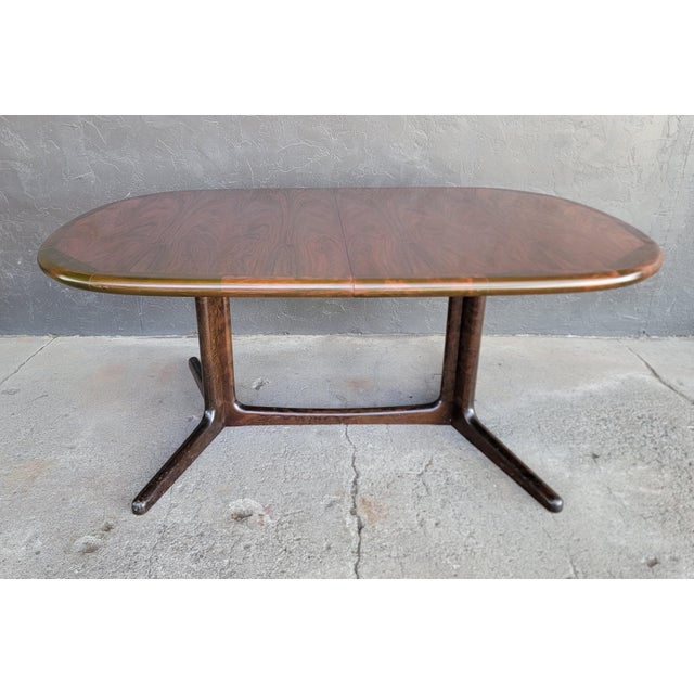 A rosewood Danish Modern expanding dining table. Circa. 1960. Table is unmarked, but attributed to Niels Otto Moller for...