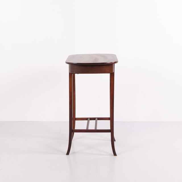 Lamp table / sewing table crafted in mahogany with a brass lock and tapered legs. Dating from around the 1920s, it can be...