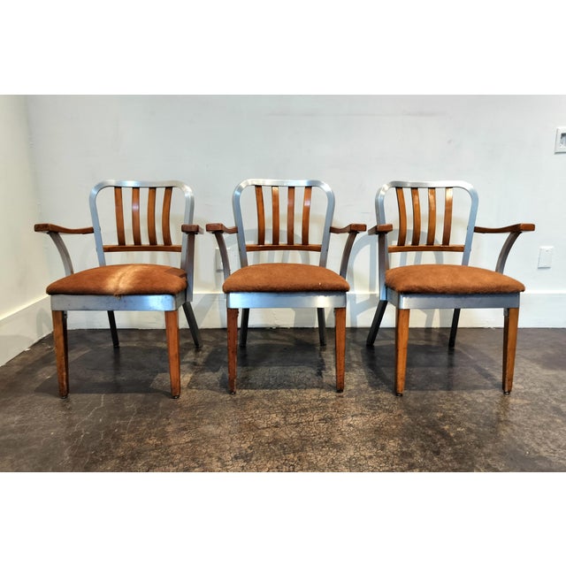 Unique set of Alcoa brand aluminum and wood chairs with cow-hide upholstery. Circa 1960's. Set of 3. Each measures 24.5"...
