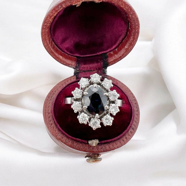 Vintage daisy ring in 18 carat gold (750 thousandths). It is decorated with a central oval sapphire of approximately 1.5...