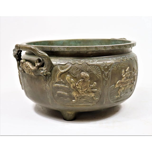 This dynamic 19th-century Meiji Period footed jardinière consists of six storytelling hand-carved images. The images...