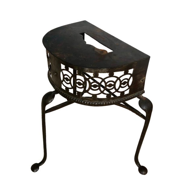 A fine English steel footman, c. 1820. The footman has a demilune form with a reticulated frieze over three short cabriole...