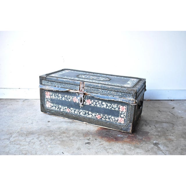 An antique, 19th-century Chinese export camphor wood chest covered in parchment, with hammered metal nail heads and...