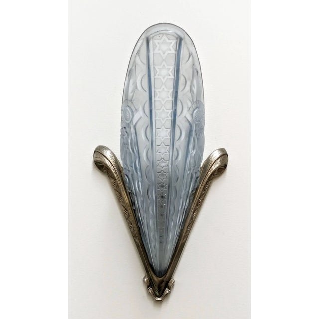 A pair of French Art Deco wall sconces by the French artist " Donna " in molded clear blue frosted glass shades decorated...