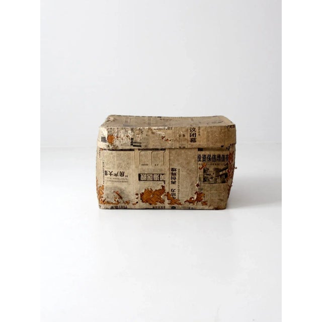 This is a paper covered Chinese storage basket circa 1981. The large woven basket features distressed newspaper and...