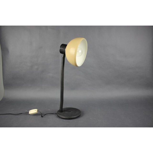 Vintage adjustable desk lamp produced in Hungary during the 1970s. The lamp features a flexible black gooseneck arm with a...