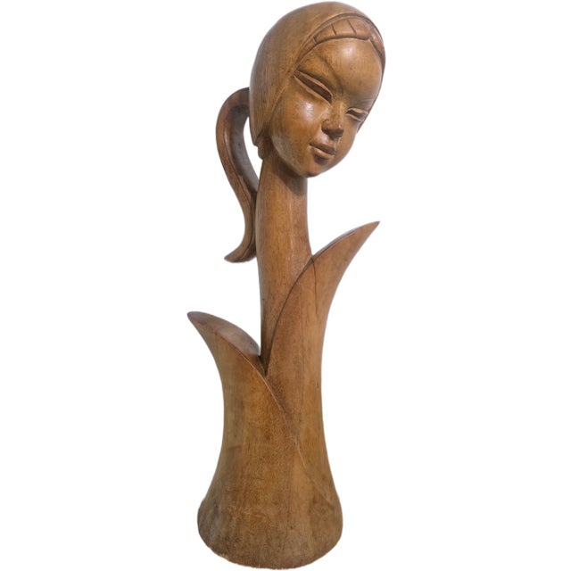 This Mid-Century Modern wood sculpture is a female bust attributeed by artist Jose P. Alcantara. It is crafted from teak...