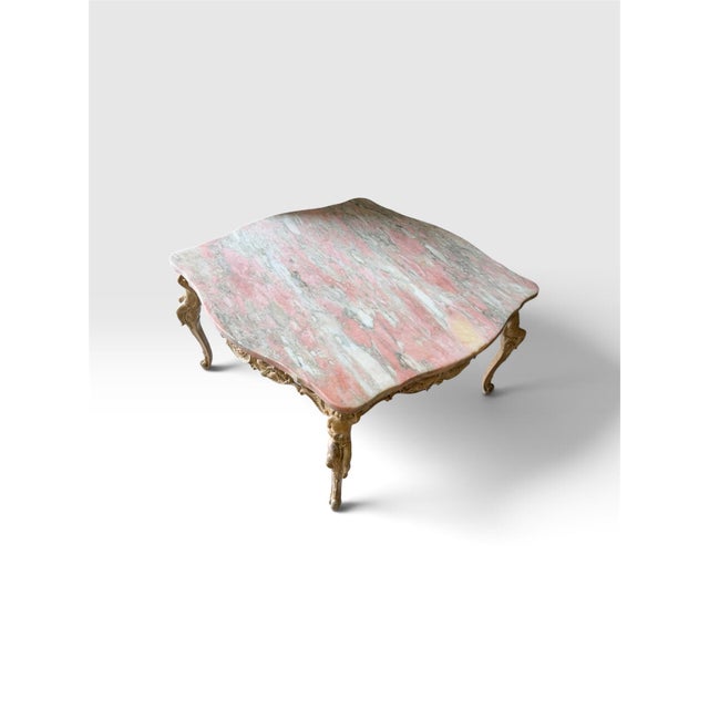 Striking vintage Rococo-style coffee table featuring a substantial shaped marble top with dramatic natural veining in...