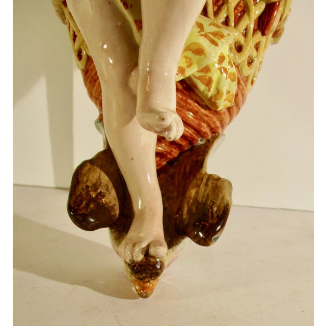 Ginori 19th century wall pocket in image of putti carrying a large grape basket. Shoulder straps over each shoulder as the...