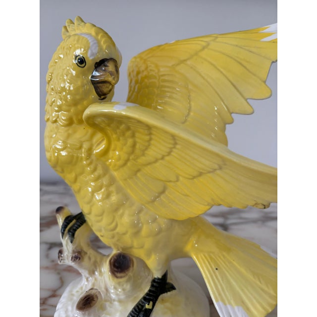 Adorable bright yellow porcelain cockatiel on a stump. It has white accents throughout. Bottom is marked “Japan”.