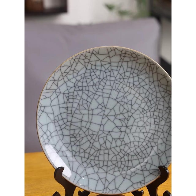 The porcelain plate with ice-crackle glaze has a diameter of approximately 24.5 centimeters, and its height including the...