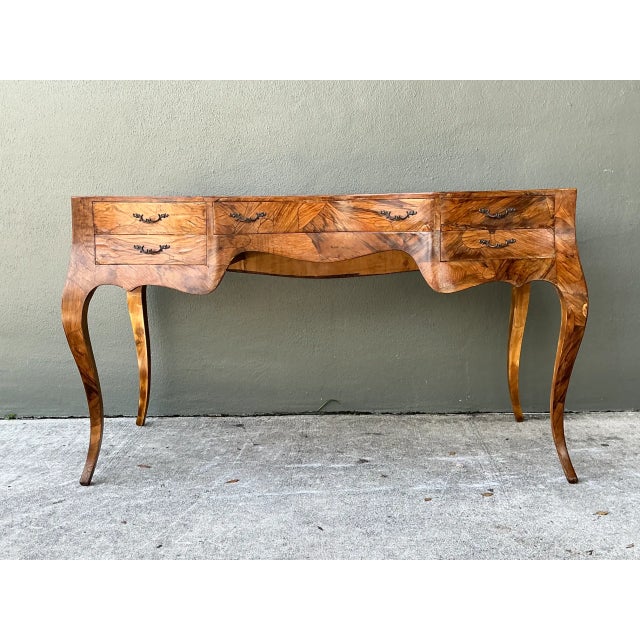 Fashioned with elegant Italian curves and book-matched olive burl wood veneers, this vintage writing desk features a...