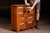 Countertop apothecary cabinet constructed in stained wood with ten graduated drawers retaining period glass drawer pulls...