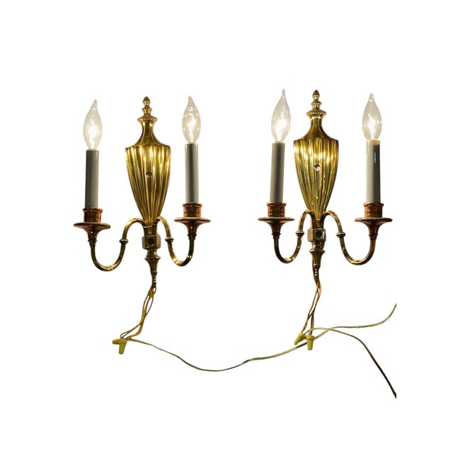 A charming pair of vintage neoclassical-style wall sconces crafted from brass and copper, featuring elegant urn-form...
