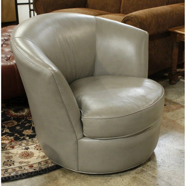 The chair features smooth gray leather upholstery with a rounded, wraparound back that creates a comfortable, enclosed...