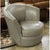 The chair features smooth gray leather upholstery with a rounded, wraparound back that creates a comfortable, enclosed...