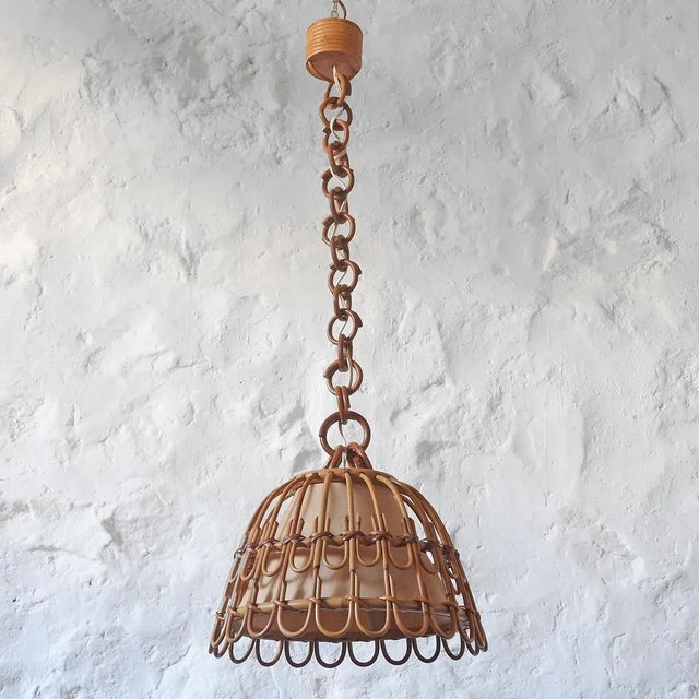 Bamboo and rattan ceiling lamp with a bell-shaped structure. It has a textured parchment diffuser and is beautiful when...
