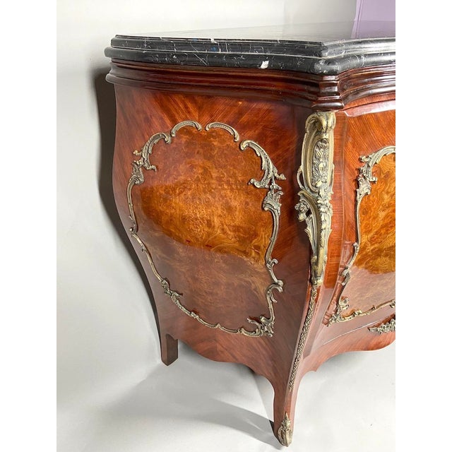 A refined 1900s French Louis XVI-style mahogany commode, beautifully crafted with elegant bronze decorations, fruitwood...