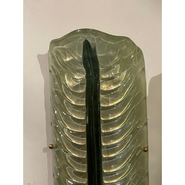 The product is a pair of modern Murano large green leaf sconces. These stylish wall fixtures add a touch of elegance and...