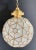 A striking Art Deco-style globe pendant featuring an intricate geometric leaded-glass design. Panels of opaque white milk...