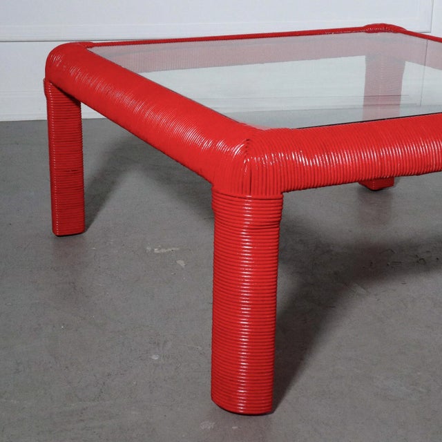 A wrapped rattan parsons style waterfall edge coffee table hand painted a bold red. Wonderful vintage condition. 33”W x...