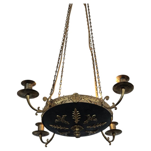 Elegant pendant in brass with decor leafs and mascarones. Two light sockets and four candle holders, Empire style Sweden...