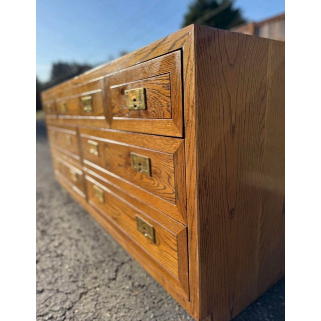 This vintage Henredon campaign-style dresser is a beautiful statement piece with timeless appeal. Crafted from solid wood...
