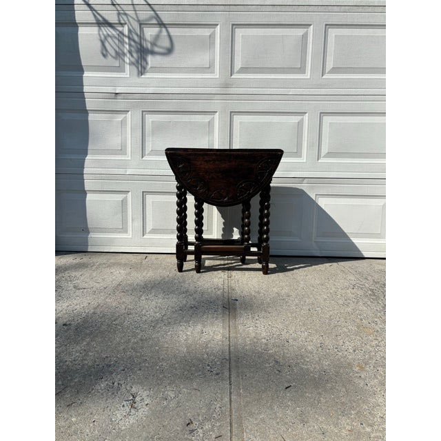 We have an absolutely stunning vintage Jacobean Revival gateleg table for sale. It features classic barley twist legs, a...
