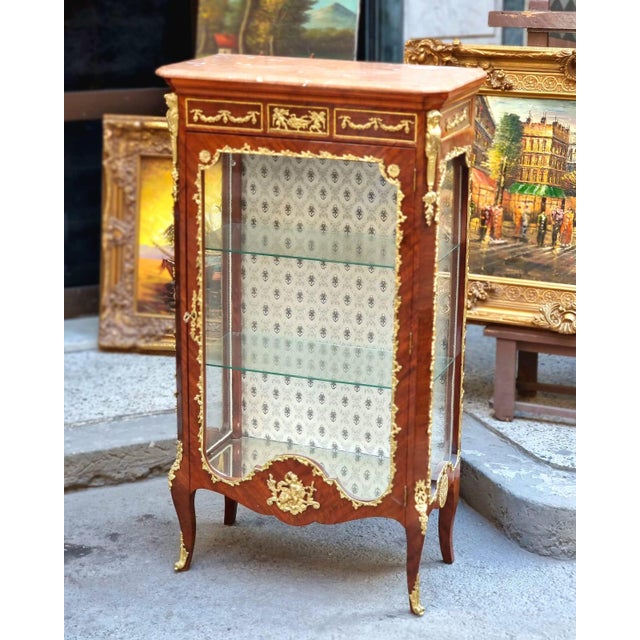 Showcase your most treasured collectibles in this magnificent French Louis XV Curio Display Cabinet, a luxurious statement...
