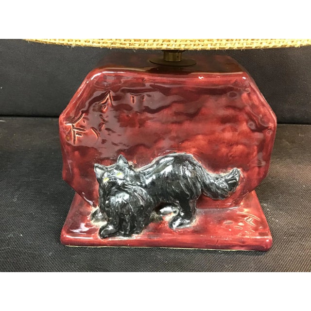 A pair of mid century handmade glazed pottery lamp with black cat with a hunched back .
