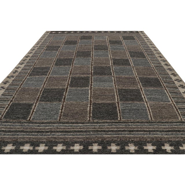 This oversized 10x14 Scandinavian kilim showcases a repeating geometric pattern in gray, blue, taupe, and ivory tones....