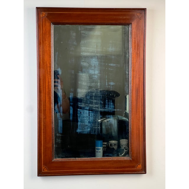 An elegant American Federal mahogany wall mirror dating to the early nineteenth century, this refined piece reflects the...