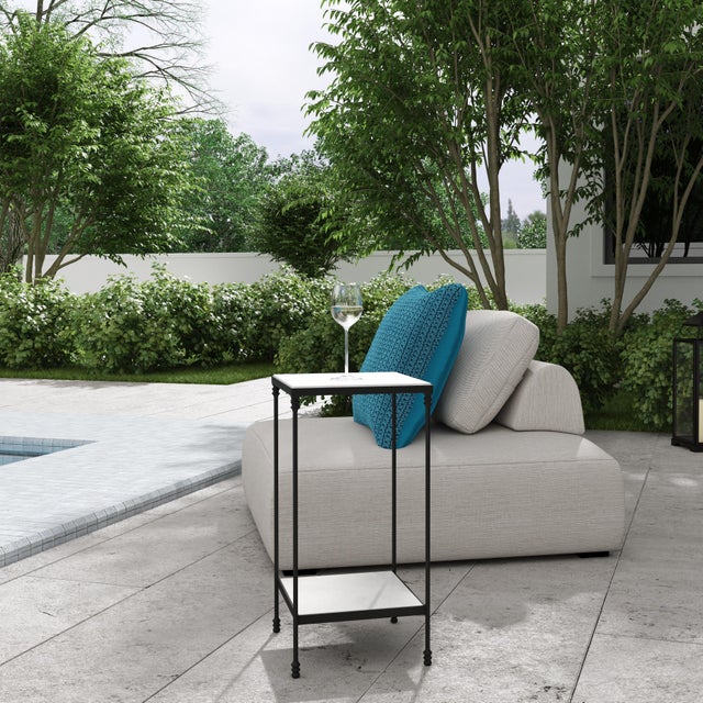 The Larkin outdoor table is a stylish square table designed for outdoor use. Its black iron frame and white marble top...