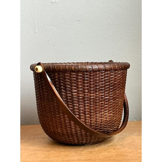 This vintage woven rattan Nantucket basket presents a robust yet refined silhouette, with a softly tapered, bucket-like...