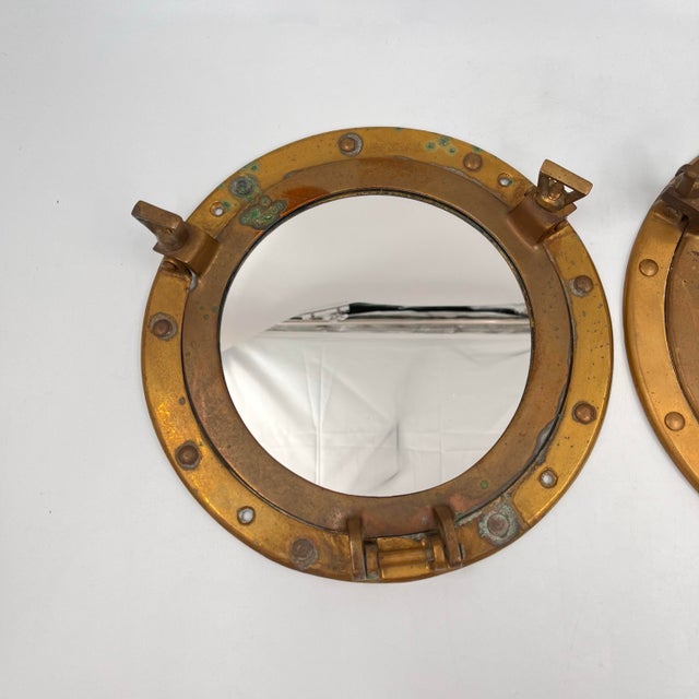 This listing is for one vintage nautical brass porthole mirror featuring two working latches and classic maritime style....