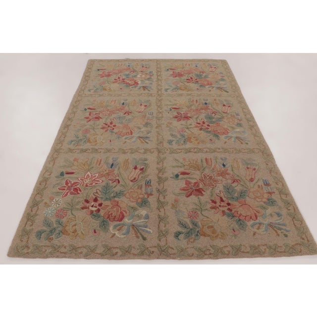 Handmade in wool, this antique hooked rug measures 6x9 and dates to circa 1920-1930. The design features repeating floral...