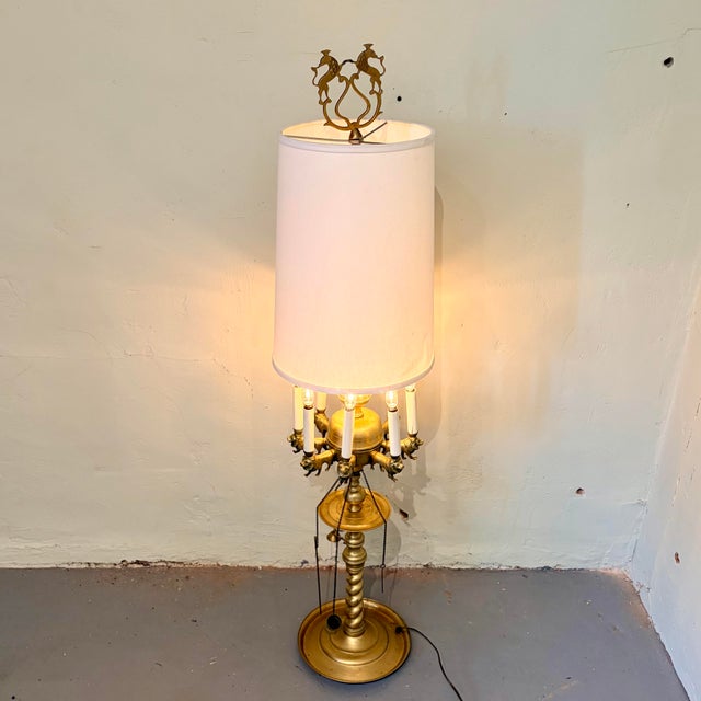 An exceptional vintage brass eight-light table lamp featuring 8 beautifully sculpted lion-form candle arms that give this...