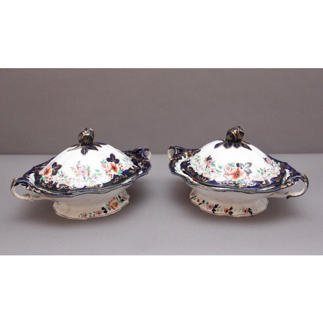 A pair of 19th Century Masons ironstone tureens of shaped oblong form, featuring scrolled handles and rose-bud finials on...