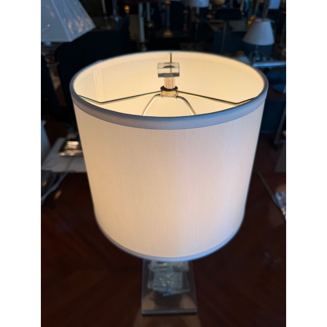 A Haig Lighting table lamp featuring a sculptural base composed of stacked clear crystal squares arranged in an...