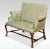 Walnut framed love seat, the solid walnut frame with a floral green upholstered back, seat and scrolling arms, raised on...