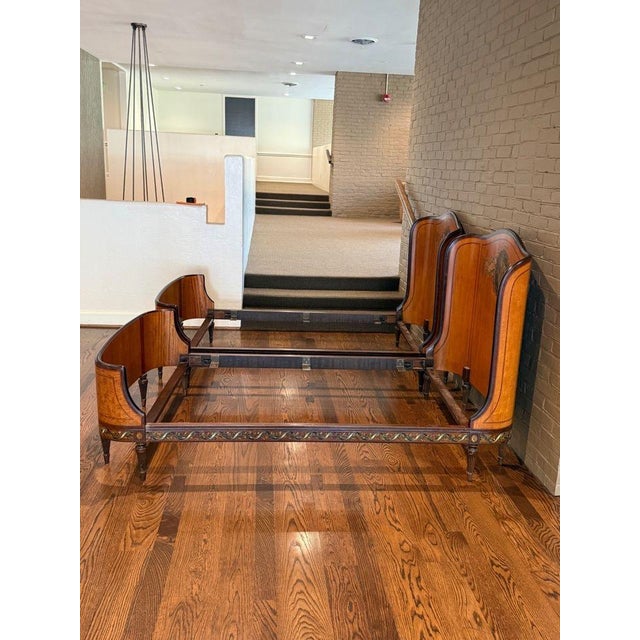 Beautiful antique satinwood and mahogany twin beds featuring handpainted details throughout. Each curved head/foot board...