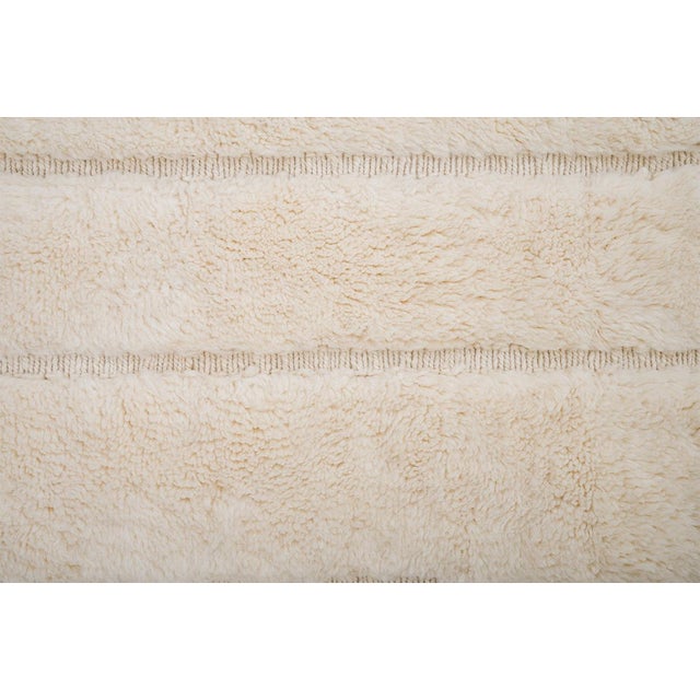 Refined hand-knotted wool rug in Soft Ivory, featuring a geometric stepped pattern. Its sculptural texture and tonal depth...