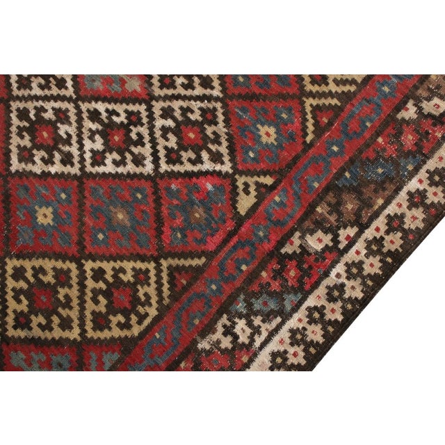 A vintage 5 x 9 Persian Kilim rug of Qashqai design lineage, handwoven in wool originating circa 1950-1960. Enjoying red...