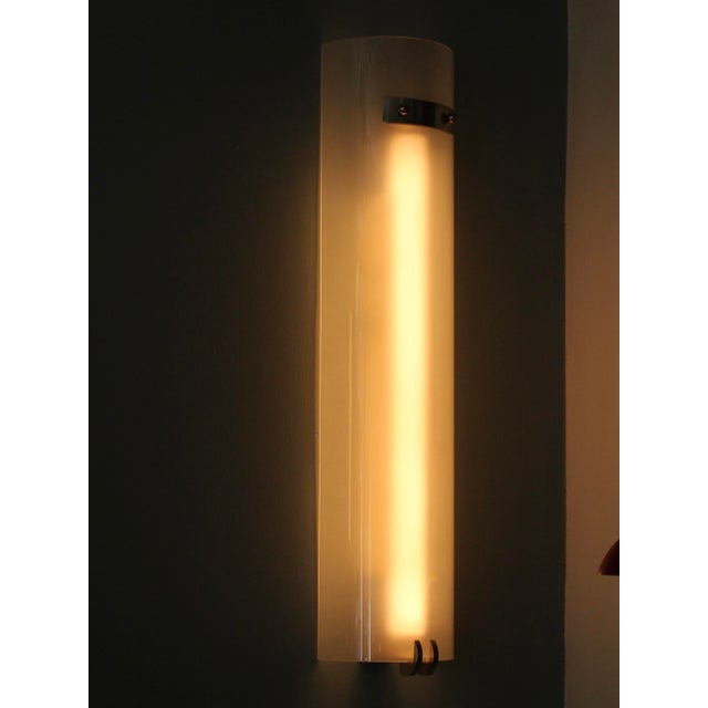 This Art Deco wall light was produced in France in the 1930s. The frosted glass half-cylinder is fixed to the underside of...